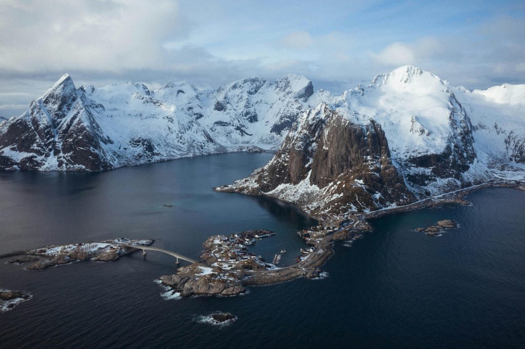 A breathtaking aerial view of snowy fjords and sea in Nordland, Norway during winter.