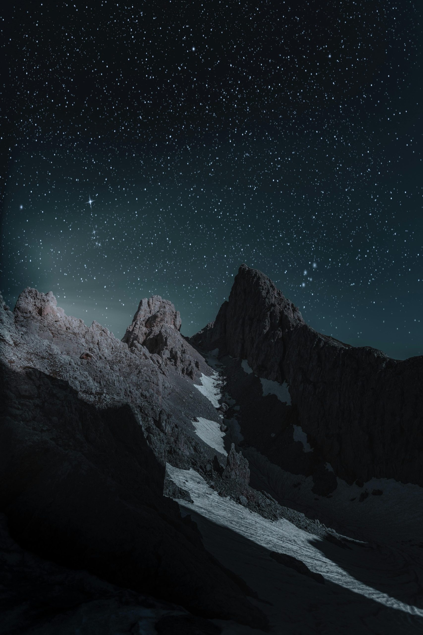 Breathtaking view of a rocky mountain peak under a starry night sky, perfect for wallpapers.