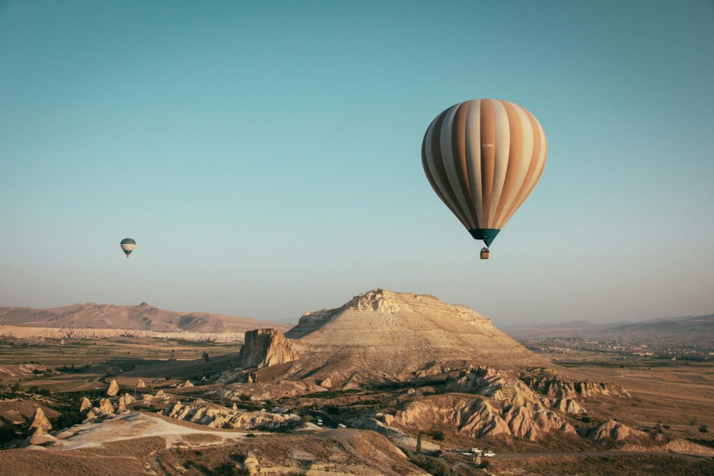 Hot air balloons float over the mesmerizing landscape of Cappadocia, Turkey at sunrise.