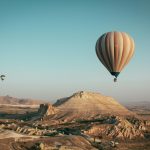 Hot air balloons float over the mesmerizing landscape of Cappadocia, Turkey at sunrise.